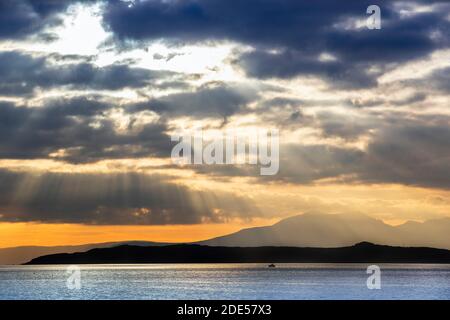 Blick nach Westen über den Firth of Clyde von der Küste von Ayrshire zur Insel Millport und Isle of Arran in der Ferne, Ayrshire, Schottland, Großbritannien. Stockfoto