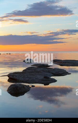 Wunderschöner Sonnenuntergang über der Küste mit Steinen. Lange Exposition, geglättete Wasser Stockfoto