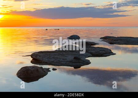 Wunderschöner Sonnenuntergang über der Küste mit Steinen. Lange Exposition, geglättete Wasser Stockfoto