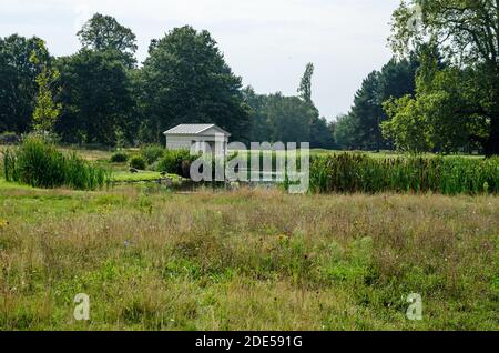 Blick über die Wiese und den See mit Blick auf den Tempel im klassischen Stil, der als Bootshaus am historischen King's Observatory im Old Deer Park, R, genutzt wurde Stockfoto