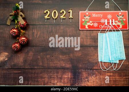 Jahr 2021 auf horizontalem dunklen Holzhintergrund mit Weihnachtsdekoration Und Masken gegen covid Stockfoto