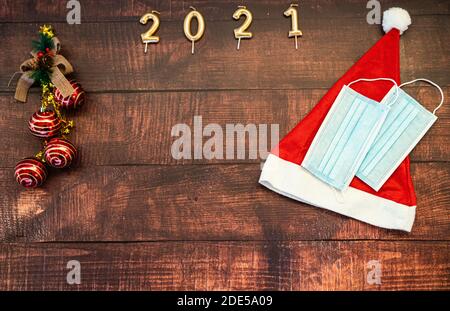 Jahr 2021 auf horizontalem dunklen Holzhintergrund mit Weihnachtsdekoration Und Masken gegen covid Stockfoto