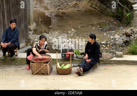 ZHAOXING DONG, CHINA - Juni 21, 2012: Chinesische Miao-minorität Frauen verkaufen frische Himbeeren fruitsand Gemüse auf der Straße. Stockfoto