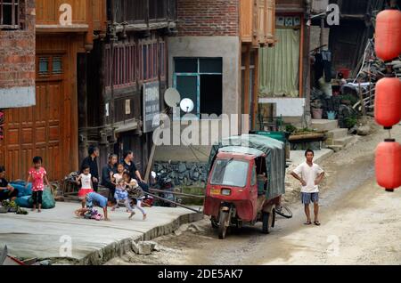 ZHAOXING DONG, CHINA - 21. Juni 2012: Die Gruppe der jungen chinesischen Miao-minorität Kinder Spaß haben und spielen auf der Straße. Stockfoto