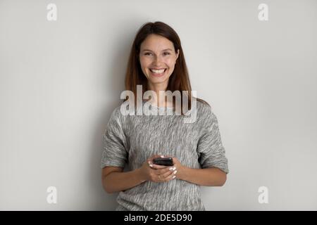 Porträt von fröhlich lächelnde Frau mit Smartphone in den Händen. Stockfoto