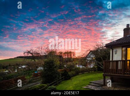 Die untergehende Sonne über dem Dorf East Budleigh in Devon. Stockfoto