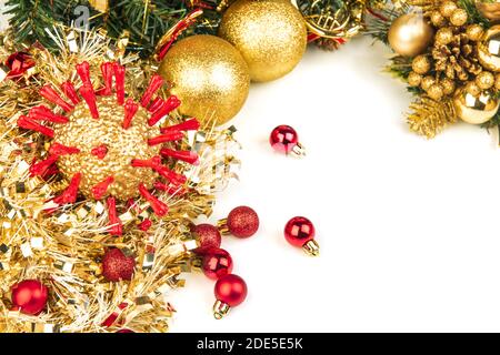 Goldene Christams Coronavirus-Kugel mit roten Eiweißspitzen, die mit anderen Feiertagsdekorationen liegen. Isoliert auf Weiß. Weihnachten 2020 sind stark betroffen Stockfoto