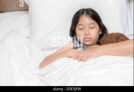 Mutter hielt ihre Tochter Hand, während sie zu Hause im Bett krank war, liebevoll und fürsorglich. Emotionale Familienmomente Stockfoto