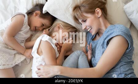 Draufsicht überglücklich Mutter und zwei kleine Töchter liegen zusammen Stockfoto