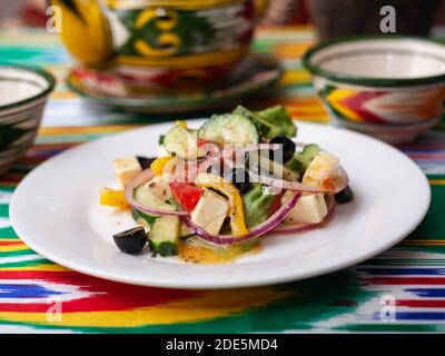 Warmer Salat aus grünen und roten Paprika, Käse, Auberginen, Zwiebeln und Tomaten im asiatischen Stil Stockfoto