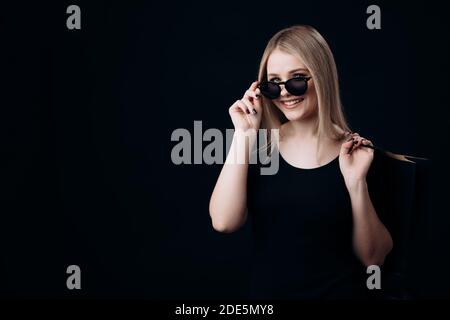 Frau mit Einkaufstaschen auf schwarzem Hintergrund Stockfoto