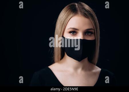 Ernsthafte Frau in Maske posiert im Studio Stockfoto