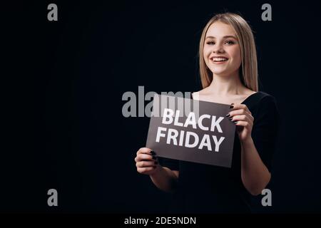 Frau zeigt Schild mit einem Black Friday Stockfoto