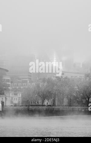 Schwarz-weiß Themse und die Gherkin durch den Nebel in der City of London an einem nebligen Morgen der Covid-19 Coronavirus-Sperre in England, Großbritannien, Europa Stockfoto