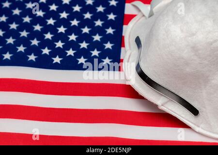 N95 Gesichtsmaske auf der Flagge der Vereinigten Staaten von Amerika. Konzept der Covid-19 Coronavirus-Pandemie, Gesichtsmaske, Gesichtsbedeckung Mandat, und zu Hause zu bleiben Ordnung Stockfoto