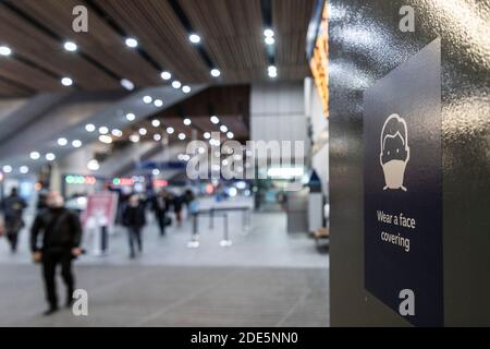 Tragen Sie eine Gesichtsmaske Schild in Covid-19 Coronavirus Lockdown in London auf öffentlichen Verkehrsmitteln an der U-Bahn-Bahnhof, für soziale Distanzierung in England, Großbritannien Stockfoto