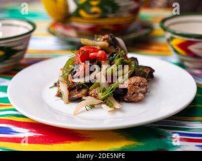 Warmer Salat aus grünen und roten Paprika, Fleisch, Auberginen, Zwiebeln und Tomaten im asiatischen Stil Stockfoto