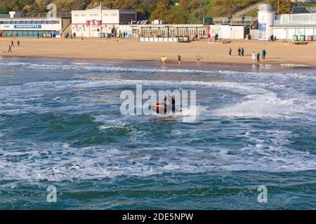 Bournemouth, Dorset, Großbritannien. November 2020. Wetter in Großbritannien: Die Strände sind voll, da die Menschen an der Küste für ihre Bewegung und frische Luft und die Sonne an einem schönen warmen sonnigen Tag an Bournemouth Strände während des letzten Wochenende der Lockdown 2 genießen. Bournemouth und Dorset werden dann in Tier2. Jetskifahrer tun akrobatische Tricks Trick. Jet Skifahrer Jetskifahrer Jetskifahrer Jetskifahrer Jetskifahrer Jetskifahrer Jetskifahrer Jetskifahren Jetskifahren Jetskifahren. Quelle: Carolyn Jenkins/Alamy Live News Stockfoto