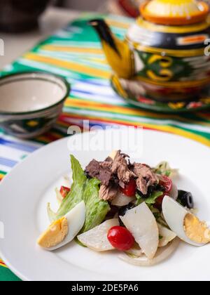 Salat mit Thunfisch. Salat mit Eiern, Kräutern, Zwiebeln, Kirschtomaten und Thunfisch. Asiatischer Stil Stockfoto