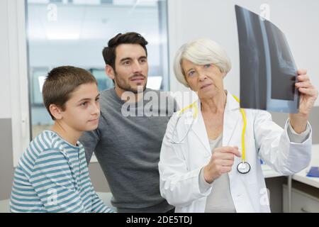 Attraktiver Arzt, der seinem Patienten eine Röntgenaufnahme zeigt Stockfoto