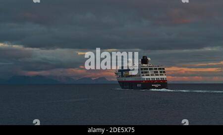 Svolvær, Austvågøya, Lofoten, Norwegen - 08-26-2020: Rückansicht des Hurtigruten-Kuiseseierschiffes MS Midnatsol, das den Hafen von Svolvaer verlässt und zum Festland fährt. Stockfoto
