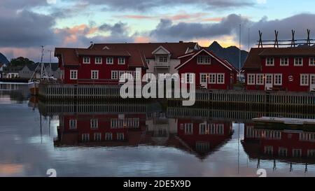 Svolvær, Austvågøya, Lofoten, Norwegen - 08-27-2020: Traditionelle Rorbu-Häuser aus Holz, die in der charakteristischen roten Farbe im Hafen gemalt sind. Stockfoto