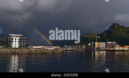 Svolvær, Austvågøya, Lofoten, Norwegen - 08-28-2020: Wunderschöne Panoramasicht auf den Hafen und die Stadtlandschaft von Svolvaer unter einem atemberaubenden, farbenfrohen Regenbogen. Stockfoto