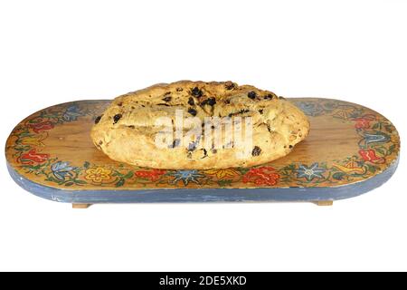 Frisch gebackener traditioneller sächsischer Weihnachtsstollen noch ohne Puderzucker Finish auf einem Vintage Holz Schneidebrett isoliert auf weiß Hintergrund Stockfoto