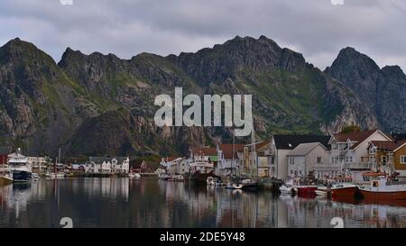 Henningsvær, Austvågøya, Lofoten, Norwegen - 08-29-2020: Traditionelles Fischerdorf auf Inseln mit Hafen, Anlegebooten und Holzhäusern. Stockfoto