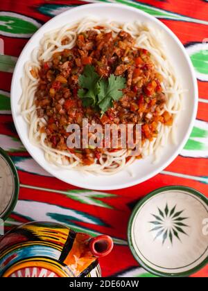 Das orientalische Gericht guiru lagman ist hausgemachte Nudeln gebraten mit Fleisch, Gemüse und Kräutern. Östliche Küche Stockfoto
