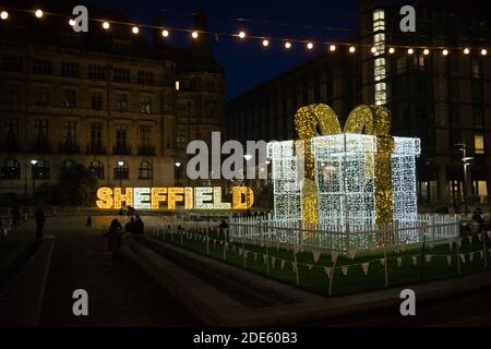 Sheffield, Großbritannien, 27. November 2020: Beleuchtet in Lichterketten, das Wort sheffield, ein großes Geschenk und Glühbirnen. Weihnachtsbeleuchtung 2020 Stockfoto