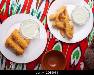 Cheese Sticks and Chicken Nuggets - gebratener Käse und paniertes gebratenes Huhn mit einer cremigen Sauce serviert. Asiatischer Stil Stockfoto