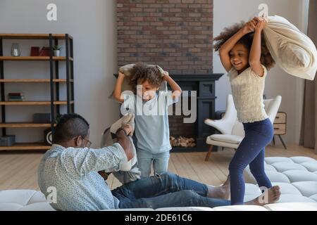 Lachende schwarze Papa Teilnahme an aktiven Spiel mit Kindern Stockfoto