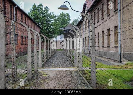 Auschwitz, Polen - 30. Juli 2018: Ein Weg zwischen zwei Stacheldrahtzäunen und Kasernen im Konzentrationslager Auschwitz-Birkenau, Polen Stockfoto