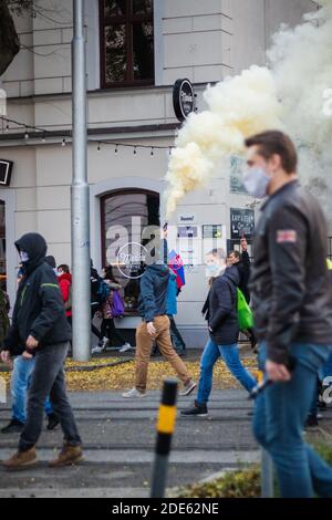 Menschenmenge, die mit einem Mann herumläuft, der die Rauchbombe hält Hands on Slovak anti governmental Demonstration gegen Corona Virus Restriktionen Stockfoto