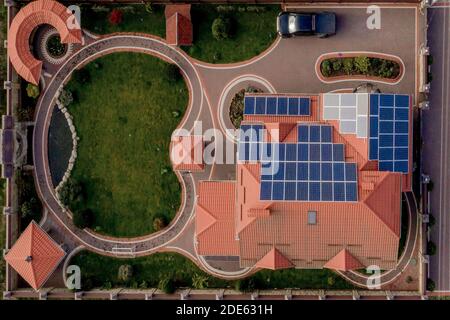 Luftaufnahme von oben von neuen modernen Wohnhaus Cottage mit blauen Paneelen. Erneuerbare ökologische grüne Energie Produktionskonzept Stockfoto