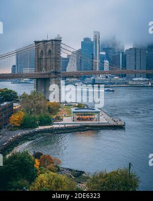 Blick auf die Brooklyn Bridge und die Skyline von Manhattan an einem bewölkten Abend von der Manhattan Bridge, New York City Stockfoto
