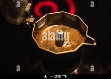 Heiße Kaffee in Moka Kaffeemaschine am Herd aus Kochendes Wasser Stockfoto