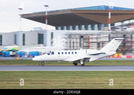 Seitenansicht des kleinen privaten Geschäfts Jet-Besteuerung auf Start- und Landebahn, in Bewegung, Flughafengebäude im Hintergrund/Business, Reisen, private Luftfahrt Co Stockfoto