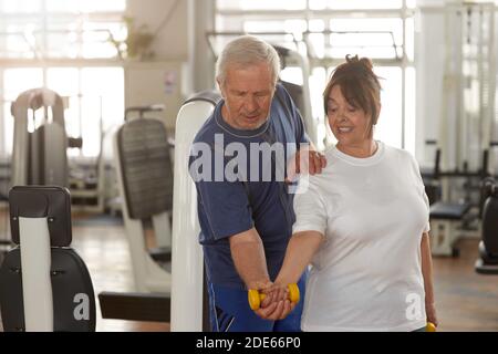Ältere Frau beim Hanteln im Fitnessstudio Stockfoto