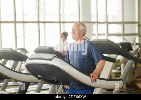 Älterer kaukasischer Mann auf dem Laufband im Fitnessstudio. Stockfoto