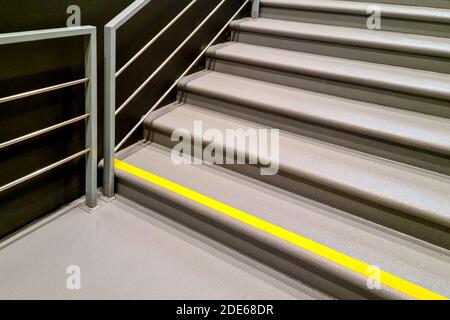 Gelbes Warnschild auf Treppen, das eine potenzielle Gefahr anzeigt, steile Treppen und Vorsicht beim auf- oder Absteigen Stockfoto