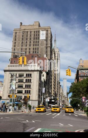 Gelbe Taxis hielten an der Ampel mit dem Empire State Building im Hintergrund, New York, USA Stockfoto