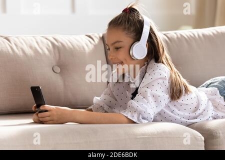 Happy girl in Kopfhörer Video auf dem Smartphone ansehen Stockfoto