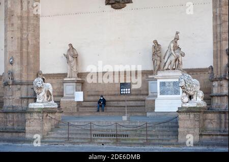 Florenz, Italien - 2020. November 19: Die Loggia dei Lanzi wurde während der Aussperrung der Pandemie Covid-19 für die Öffentlichkeit gesperrt. Ein Hausmeister bewacht den Eingang. Stockfoto