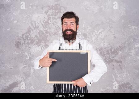 Fröhliche gastfreundliche Restaurant Kellner mit Kreidetafel, Kopierer Raum. Beste Wahl. werbung und Essen. Kochen nach Rezept. Meisterkurs vom Koch Mann. Bestes Angebot für Abendessen. Chef Bäcker Menü. Stockfoto