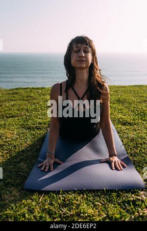 Porträt einer Yogalehrerin, die ihren Körper außerhalb des Hauses streckt. Speicherplatz kopieren Stockfoto