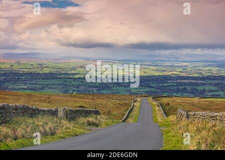 Blick auf eine Landstraße in der Nähe von Staimore mit dem Eden Valley in der Ferne, Cumbria, England, Großbritannien. Stockfoto