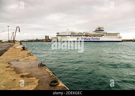 Die Pont Aven von Brittany Ferries liegt am Kai des Hafens Port du Bloscon in Roscoff, Bretagne, Frankreich, fotografiert vom Hafenmolen mit Ankerleinen und Pollern im Vordergrund. Die Fähre ist das Flaggschiff von Brittany Ferries und seit 2004 auf der Route Roscoff–Cork im Einsatz. Stockfoto