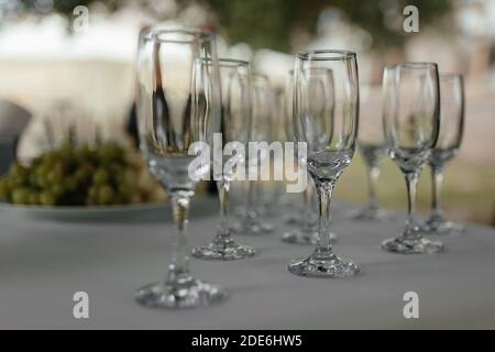 Leere Sektgläser am weißen Tisch mit dem Platz für Ihren Text. Weinglas. Alkoholparty Stockfoto